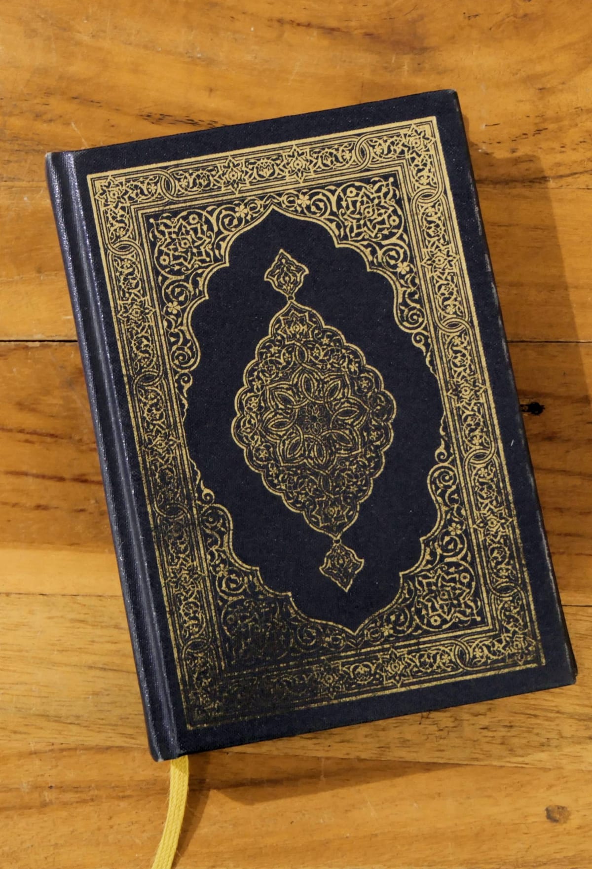 Koran met goudkleurige sierrand op een houten tafel