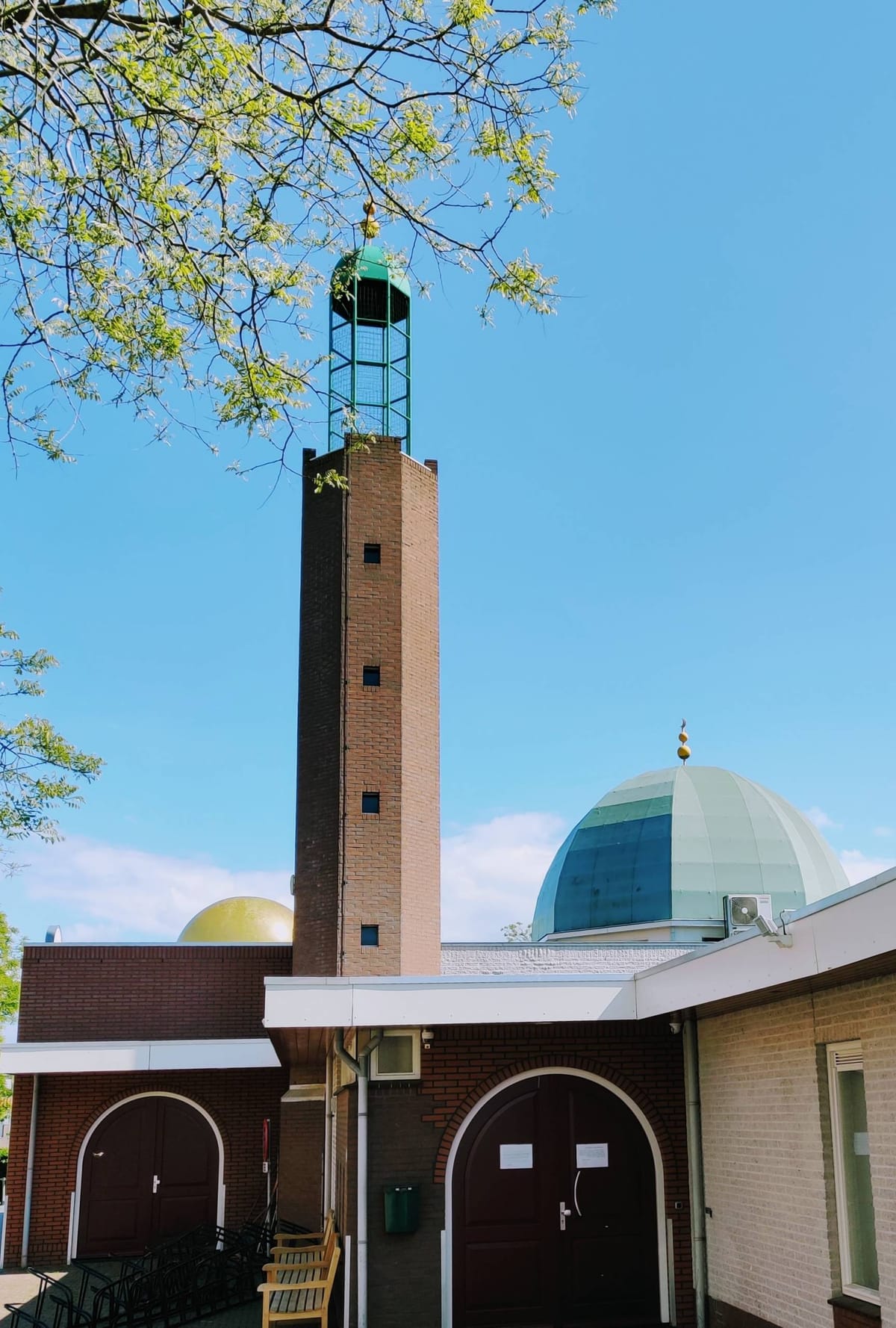 Minaret en koepel van Moskee An-Nasr tegen een blauwe lucht