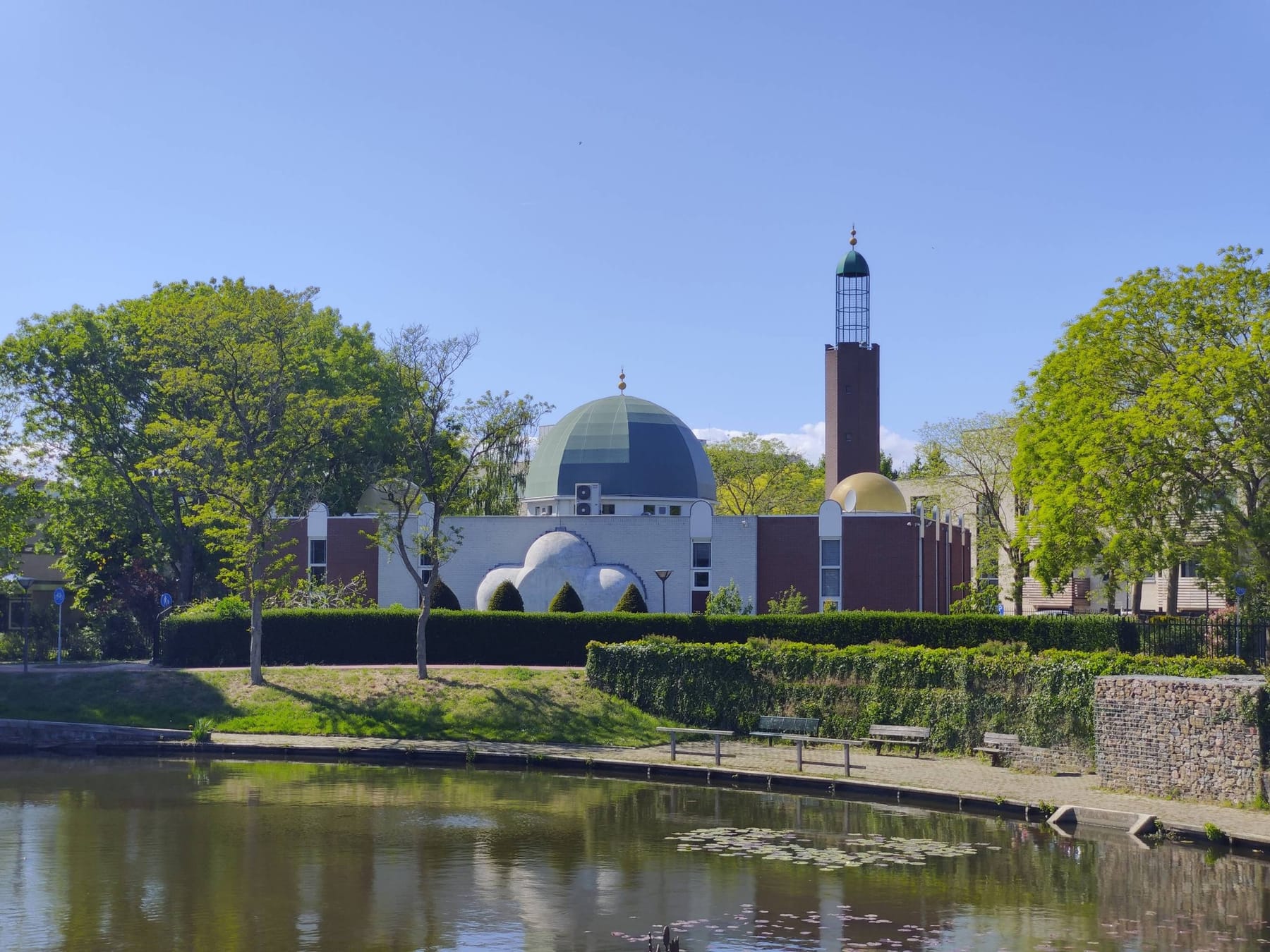 Moskee An-Nasr in Huizen gezien vanaf het water, met groene koepel, gouden koepeltje en bakstenen minaret